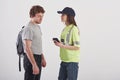 Modern people. Pretty woman in green police uniform have conversation with male student against white background in the Royalty Free Stock Photo