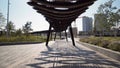 Modern pergolas in park on sunny day. Action. Long pavilions or pergolas in modern city park. Beautiful architectural