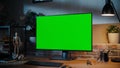 Modern Personal Computer Monitor with Green Screen Mock Up Display Standing on the Desk with