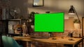 Modern Personal Computer Monitor with Green Screen Mock Up Display Standing on the Desk with