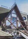 Modern photo of a rural rustic facade  balcony of a stylish cottage . Window of mansard of the wooden house against the summer blu Royalty Free Stock Photo