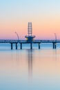 Modern pier with curving lines glowing at sunrise, reflections i Royalty Free Stock Photo