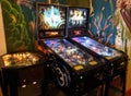2 modern pinball machines with a 70s cocktail table machine