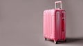modern pink suitcase on wheels close-up on gray background travelling concept copy space generative AI