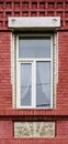 A modern plastic double-glazed window in the window of an old brick building with elements of stucco decoration Royalty Free Stock Photo