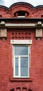 A modern plastic double-glazed window in the window of an old brick building, a fragment of the facade