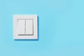 Modern plastic light switch on blue wall, space for text Royalty Free Stock Photo