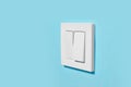 Modern plastic light switch on blue wall, space for text Royalty Free Stock Photo