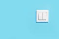 Modern plastic light switch on blue wall, space for text Royalty Free Stock Photo