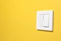 Modern plastic light switch on orange background. Space for text Royalty Free Stock Photo