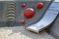 modern Playground with a metal slide inscribed in a contemporary landscape design stairs made of red hemispheres, made on the Royalty Free Stock Photo