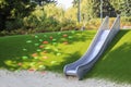 modern playground with a metal slide inscribed in the landscape Royalty Free Stock Photo