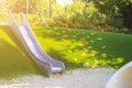 modern playground with metal slide inscribed in landscape design with ladder of plastic shells made on hillside Royalty Free Stock Photo