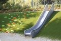 modern playground with a metal slide inscribed in the landscape design with a ladder of plastic shells made on the hillside Royalty Free Stock Photo