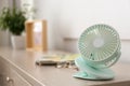 Modern portable fan on wooden table indoors, space for text. Summer heat