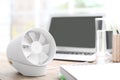 Modern portable fan on wooden table in office, space for text. Summer heat Royalty Free Stock Photo