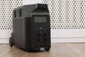 Modern portable power station on floor indoors, space for text Royalty Free Stock Photo