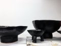 Modern pottery on wooden shelf. Decorative ceramic plate. Handmade dark pottery. Ceramic clay empty handmade bowl and cup on dark