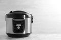 Modern powerful multi cooker on table against light background.