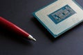 Modern powerful processor of a personal computer compared to the tip of a fountain pen. Black background. Computer assembly.