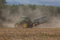 A modern powerful tractor plows a field.