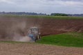 A modern powerful tractor plows a field.