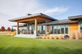 modern prairie house, sleek design, central chimney, green grass around