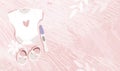 Modern pregnancy banner with copyspace for text, pregnancy test, baby bodysuit and booties on a pink background