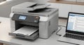 A modern printer with a laptop on a desk in an office setting Royalty Free Stock Photo