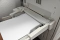 Modern printer with paper indoors, closeup. Printing house Royalty Free Stock Photo