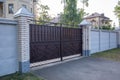 Modern private brown wrought iron large gate of the house. Home design and decoration ideas. Iron door for yard fencing. Facade of