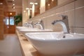 Modern public bathroom concept row of white ceramic washbasins, faucets