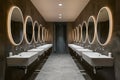 Modern public bathroom with row of white ceramic wash sinks Royalty Free Stock Photo