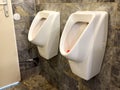 Modern public restroom urinals on stone tiled wall Royalty Free Stock Photo
