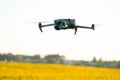 A modern quadcopter flies over a field of sunflowers against the sunset. The use of modern technologies in the agro-industrial Royalty Free Stock Photo