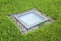 Modern quadrangular metal spotlight led lamp for outdoor use with square shape recessed in a grass floor Royalty Free Stock Photo