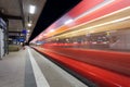 Modern railway station with high speed passenger train on railroad track in motion at night Royalty Free Stock Photo