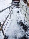 Modern ramp with metal railings for accessible movement of people with disabilities, ramp covered with snow, top view