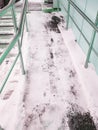 Modern ramp with metal railings for accessible movement of people with disabilities, ramp covered with snow, vertical Royalty Free Stock Photo