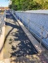 Modern ramp with shiny metal railings outdoors, wheelchair accessible, close-up, vertical