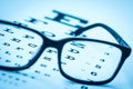 Modern reading glasses on a eye sight test chart Royalty Free Stock Photo
