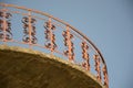 Modern red balcony, red openwork wrought iron fence with heart shapes against blue sky, railings, exterior of a building