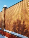 Modern red brick fence with turrets, in winter, outdoors
