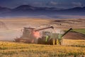 A modern red combine harvester is busy harvesting wheat on a wheat farm in the Overberg of South Africa Royalty Free Stock Photo