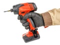 Modern red cordless screwdriver in worker hand in black protective glove and brown uniform isolated on white background Royalty Free Stock Photo