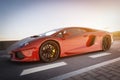 Modern red metallic sports car driving fast on the road. Generic desing, brandless Royalty Free Stock Photo