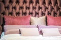 Modern red, pick, beige colorful pillows and brown cushion headboard on a the bed interior for home and living achitecture Royalty Free Stock Photo