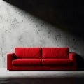 Modern red sofa against a textured concrete wall with dramatic lighting in a studio Royalty Free Stock Photo