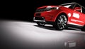 Modern red SUV car in a spotlight on a black background. Royalty Free Stock Photo