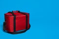 Modern red thermo bag on light blue background. Space for text Royalty Free Stock Photo